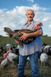 Official Frank Reese photo holding turkey in field